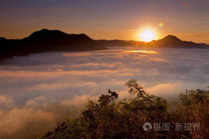 太阳升起从山与美丽的金色光雾