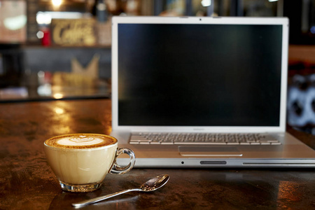 笔记本电脑与新鲜杯咖啡