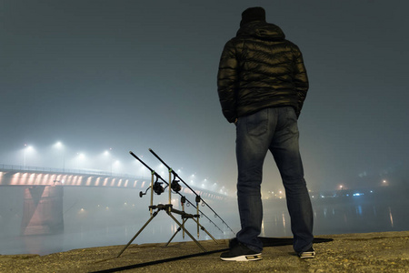 渔夫在雾气朦胧的夜晚照片