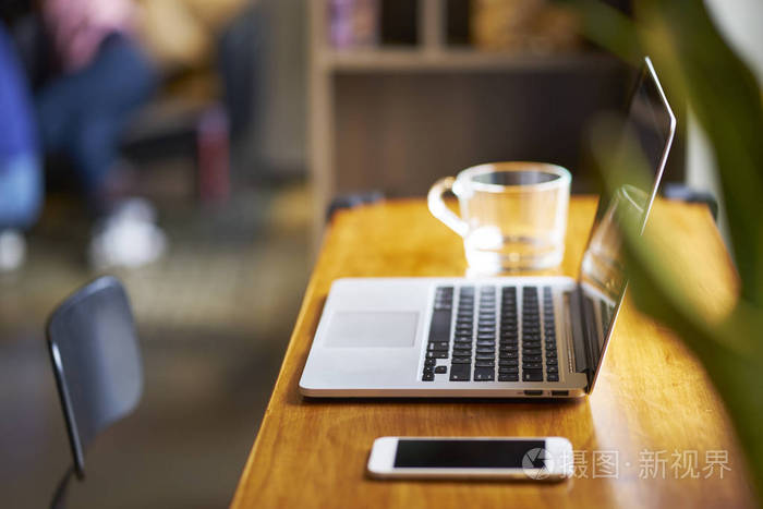 咖啡店桌上的手提电脑,智能电话和水杯