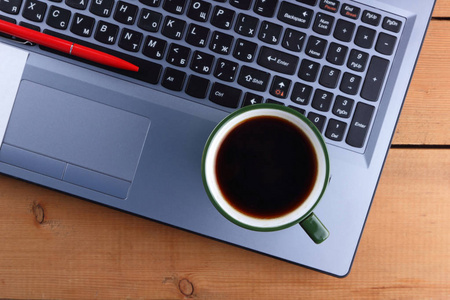 笔记本电脑和咖啡杯的木质背景, 旧办公桌, 智能手机和钢笔在键盘上, 复制空间, 设计师工作站, 经理的工作场所, 艺术