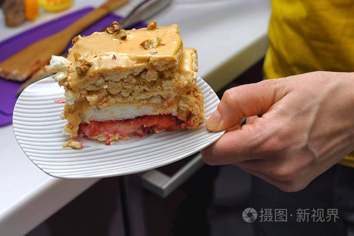 手拿着一块白色的盘子, 一块美味的 b 蛋糕.