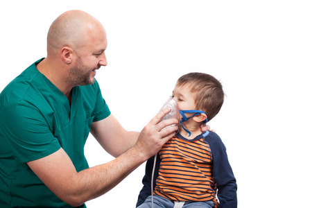 医生拿著面具吸入器在一个小男孩。治疗哮喘。通过蒸汽雾化器的呼吸。吸入治疗仪，白色衬底上分离的概念