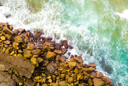 蓝色波浪在岩石澳大利亚海岸线上坠毁的高空鸟瞰图。夏季海景与海浪和悬崖。旅游理念背景