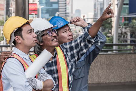 建筑师, 土木工程师和施工现场的工人一起工作在建筑的蓝图上。团队理念