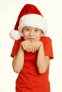 男孩儿童肖像在圣诞老人的帽子，玩乐和情绪，冬天假日概念，黄色色调