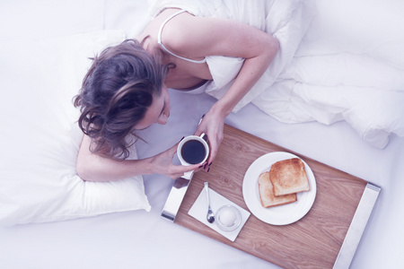 躺在床上吃早餐的女人