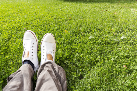 坐在草地上的男人穿的运动鞋特写
