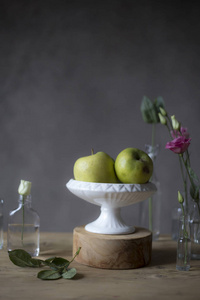 木桌上花瓶里的青苹果