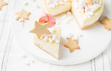 一块经典的芝士蛋糕 纽约 与装饰 生姜饼干, 棉花糖和糖果的轻木背景。最好的庆典背景。冬季圣诞假期概念