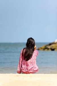 一个年轻的妇女独自思考, 看着大海的背面视图