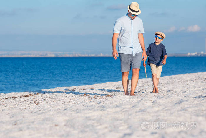 快乐的父亲和他的儿子在海滩很开心