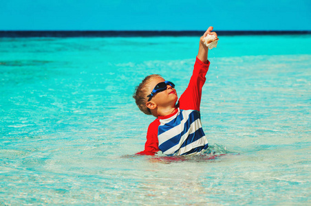 快乐的小男孩在热带海滩游泳