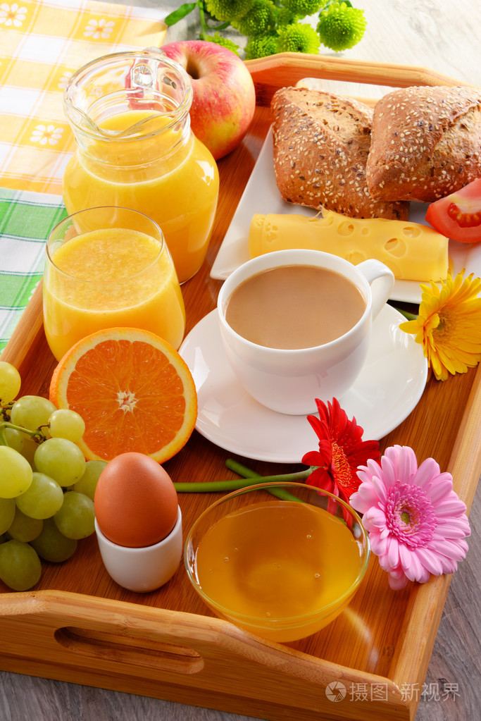 酒店的早餐托盘配咖啡,果汁, 鸡蛋和面包卷