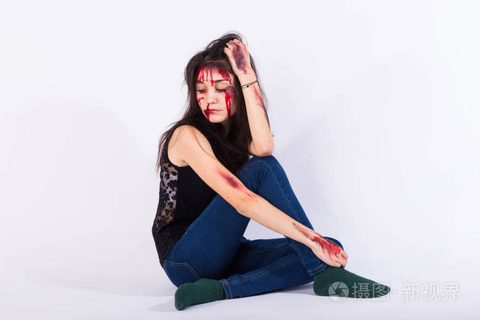 坐在地上的年轻女子身上有血迹和瘀青, 性暴力, 性虐待, 贩卖人口