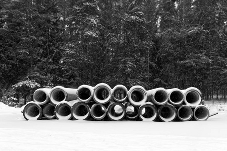 水泥森林水泥管上的雪在堆栈中黑色和白色照片