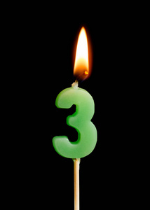 燃烧蜡烛以三个数字 数字, 日期 的形式在黑背景被隔绝的蛋糕.