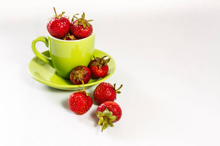 新鲜多汁草莓在绿色杯子和飞碟隔绝在