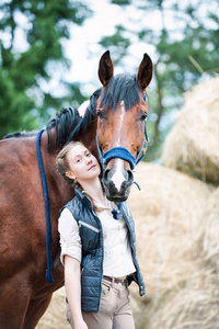 年轻漂亮的少女马术拥抱她最喜欢的马