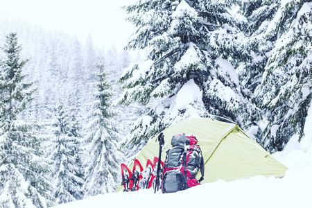 冬季徒步旅行。在山里徒步旅行带着背包和帐篷雪的冬天