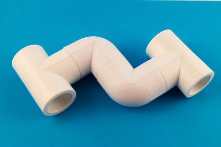蓝色背景的三个白色塑料三通, 从 pvc 管道创建供水系统的连接单元