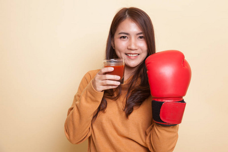 年轻的亚裔女子和番茄汁和拳击手套