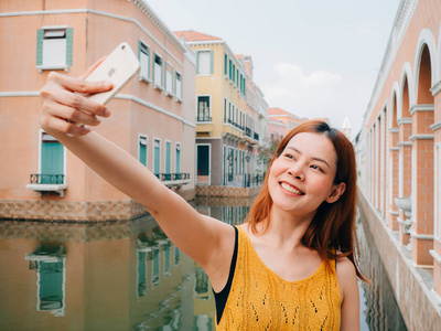 女游客正在从智能手机上拍摄自拍照片
