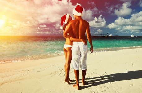 夫妇在海滩上圣诞的帽子