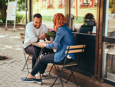 夫妇约会喝咖啡, 坐在咖啡店附近。在户外约会