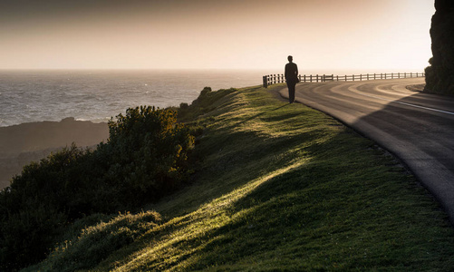 漫无孤独的女孩子走沿着海岸悬崖路 / 漫无目的地游荡照片