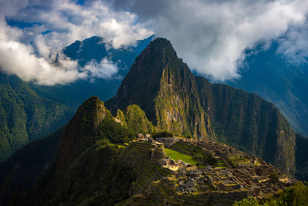 马丘比丘被从开放云出来的第一束阳光照亮。印加的城市是在秘鲁访问量最大的旅游目的地。雾 云和雾覆盖的山谷