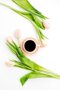 白色背景的粉红色郁金香花和杯咖啡。平躺, 顶部看法静物概念