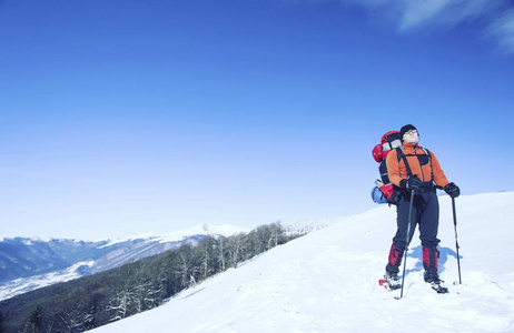 冬季徒步旅行。在山里徒步旅行带着背包和帐篷雪的冬天