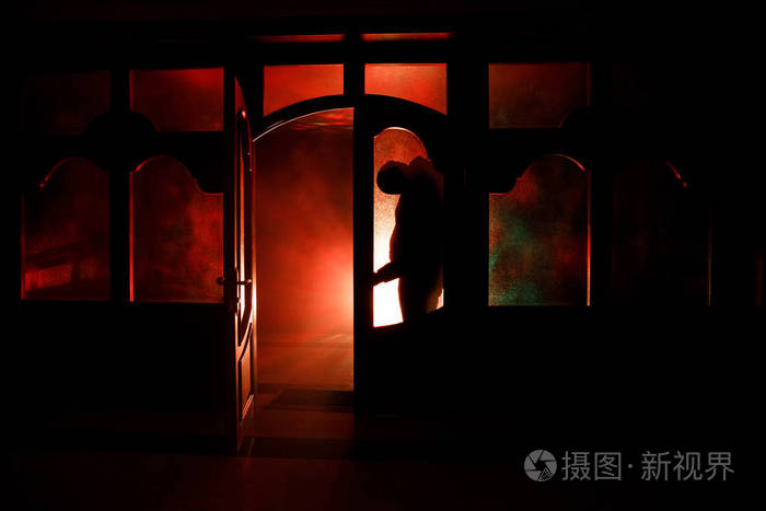 一个人在夜晚的窗口前的剪影.恐怖场面万圣节模糊剪影概念