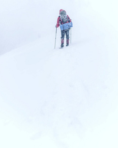 冬季徒步旅行。在山里徒步旅行带着背包和帐篷雪的冬天