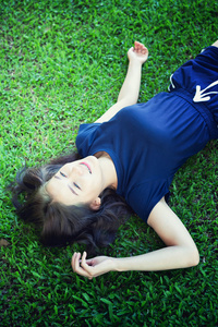 亚洲妇女在绿草中放松