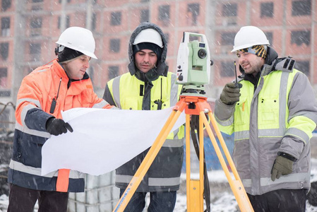土建工程师施工现场施工现场施工人员男子在头盔, 硬帽子持有建筑计划