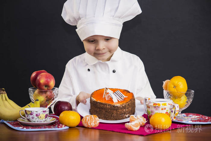 小男孩厨师煮熟的水果蛋糕