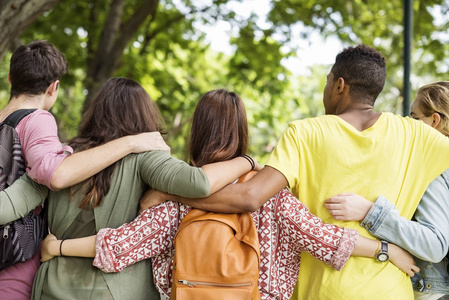 乐趣粘接不同的年轻朋友粘接户外照片