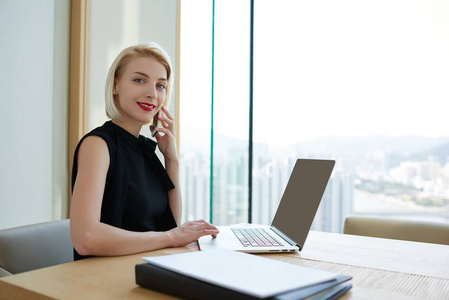有经验的金发女 Ceo 的肖像在办公室在线工作时有电话商务交谈, 公司联系财务经理的繁荣所有者通过应用检查收入