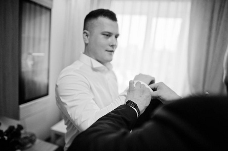 最佳男子帮助穿在他的婚礼上新郎。黑色和白色