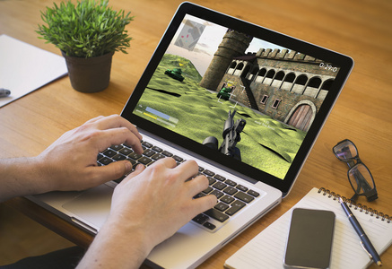 玩游戏在笔记本电脑上玩游戏的人照片