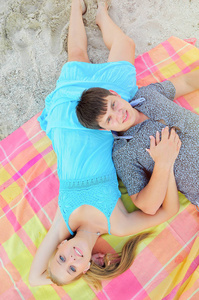美丽浪漫的情侣躺在沙滩上