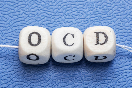 在蓝色背景上的木制多维数据集上字 ocd 强迫症