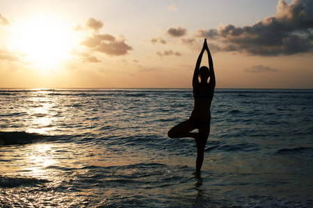 vrikshasana 树姿势从瑜伽的女人剪影上日落照片