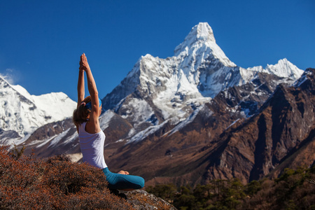 年轻女子正在练习瑜伽对喜马拉雅山脉