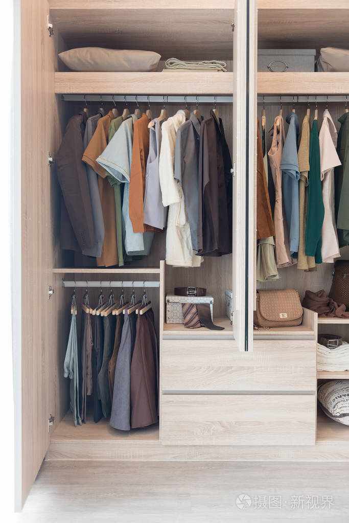 挂在木制衣柜栏杆上的衣服