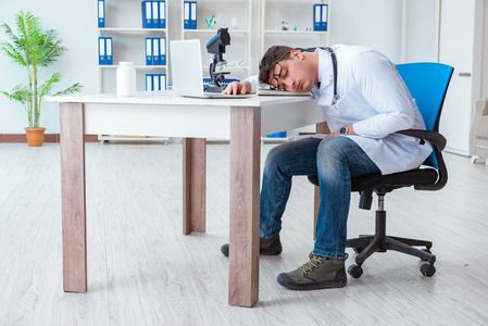 疲倦的医生在夜班以后急诊医生闹钟紧急检查概念累了的女医生