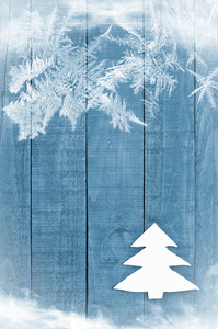 白色圣诞树由木 蓝色背景上的感觉。雪化作乌影图像。圣诞树装饰工艺