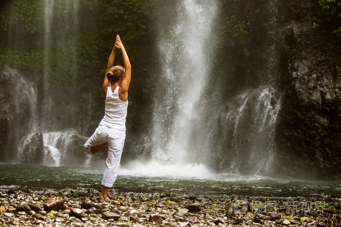 冥想的女人做瑜伽之间瀑布